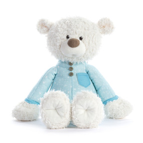 A white teddy bear wearing a light blue pair of pajamas.