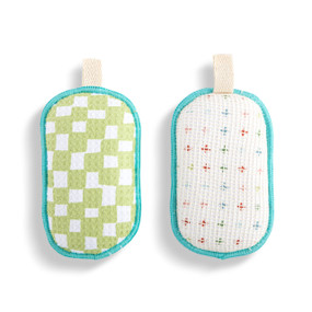 A set of two absorbent sponges in light green and white check pattern. Each has a fabric tab at the top for hanging.