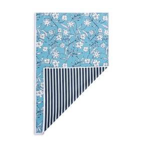 A rectangular double sided towel. One side is blue with illustrated white flowers and the other is navy and white striped, displayed with the navy corner turned back.