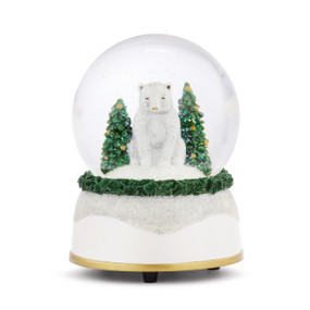 A musical snow globe with a white base and a white polar bear sitting with two decorated trees inside.