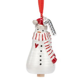 A small white bell shaped like a snowman wearing a red and white stiped scarf and has a silver metal candy cane charm at the top.