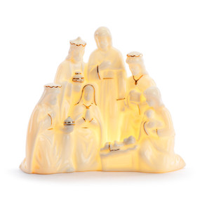 A white ceramic figure of the holy nativity that lights up, displayed lit.