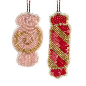 Two fabric ornaments shaped like candy and decorated with pink red and gold beads and sequins.