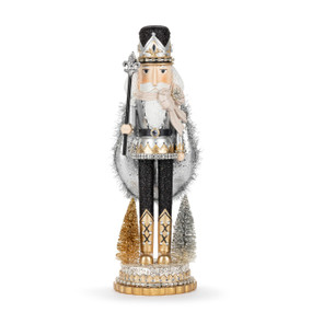 A nutcracker figure wearing black and silver and decorated with gold and silver sparkle.