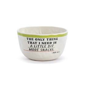 A white crinkly melamine bowl with a green rim and the saying "The only thing that I need is a little bit more snacks".