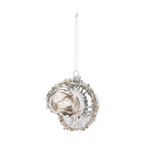 A glass ornament shaped like a shell and decorated with silver and gold beads and glitter.