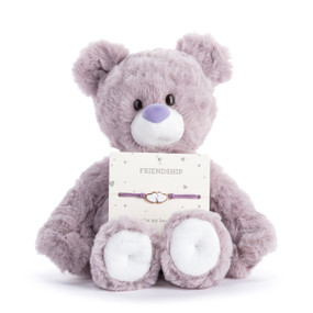 A light purple plush teddy bear with an attached friendship bracelet with two white hearts intended for a child.