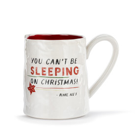 A white ceramic mug with a crinkly appearance. The interior is red and the saying "You can't be sleeping on Christmas" is on the front.