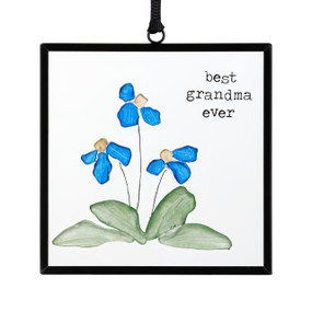 A small square suncatcher with blue flowers and green leaves made out of small stones and the saying "best grandma ever".