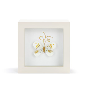 A white and gold butterfly with gold wire tentacles in a white shadow box.