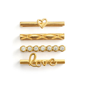 Four different gold charms that fit on a smart watch band. One has a heart charm and another has the word "Love".