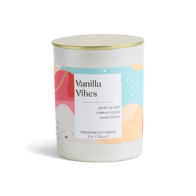 An 8 oz vanilla vibes scented candle in a round white container with a gold lid.
