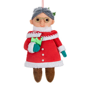 A fabric ornament of Mrs. Claus holding a green package.