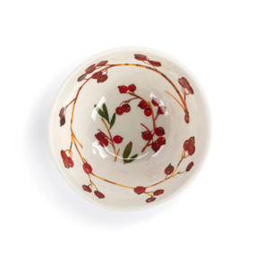 Top down view of a white dip bowl with illustrated cranberries on branches inside.