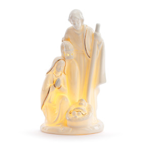 A white ceramic figure of the holy family that lights up, displayed lit.