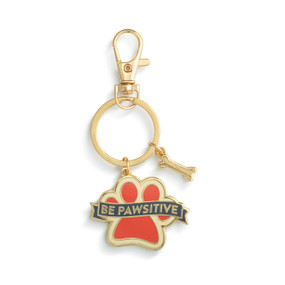A gold keychain with two charms. One is a small gold bone and the other is shaped like a paw and has the saying "Be Pawsitive".