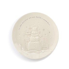 A cream ceramic plate with an image of a snowman in the forest and the saying "in the meadow we can build a snowman".
