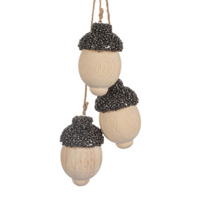 An ornament of three wood carved acorns covered with small gray beads for the tops.