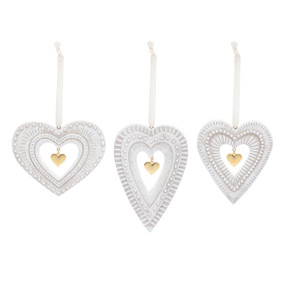 Three different white heart paper pulp ornaments with a cutout in the middle and a gold heart charm.