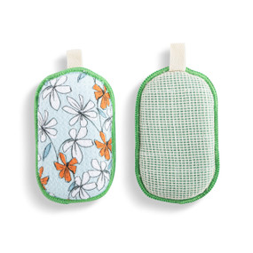 A set of two absorbent sponges in light green with white and orange illustrated flowers. Each has a fabric tab at the top for hanging.