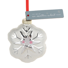 A blown glass ornament of a white smiling snowflake. There is a gray tag with the saying "You are my no matter what friend".