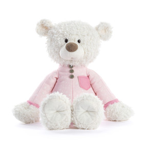 A white teddy bear wearing a light pink pair of pajamas.