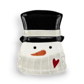 A white ceramic spoon rest shaped like a snowman's head with a gray scarf and black top hat.