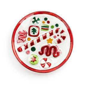 A mini round glass plate with images of holiday candy and a red rim.