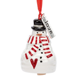 A small white bell shaped like a snowman wearing a red and white striped scarf and has a silver metal tag with the word "love" at the top.