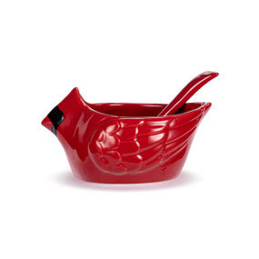 A small red ceramic bowl shaped like a cardinal with a small red spoon sitting inside.