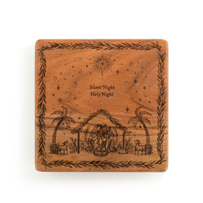 A square wood trivet with an etched image of the holy family and the words "Silent Night Holy Night".