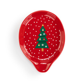 A red ceramic spoon rest with a green Christmas tree and white dots.