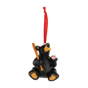 An ornament of black bear holding a baseball and baseball bat. The ornament has a red ribbon hanger.