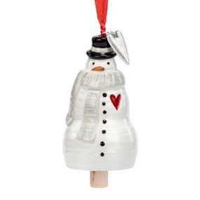 A small white bell shaped like a snowman wearing a gray scarf and has a silver metal heart charm at the top.