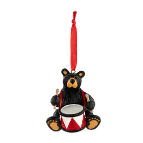 An ornament of a black bear with a snare drum hanging from a red ribbon.