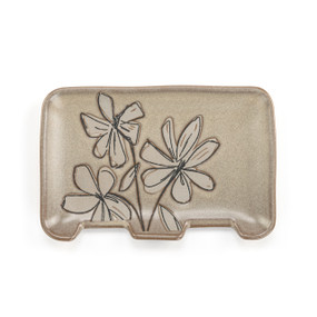 A rectangular brown ceramic double spoon rest with an illustrated flower.