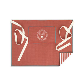 A red and white half apron with cream ties and a pocket with the saying "Grill Master Dad Perfection Takes Time".