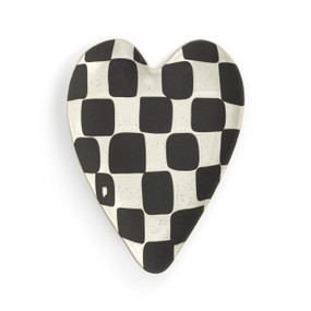 A white heart shaped spoon rest with black and white checkerboard.
