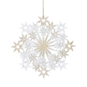 A clear star burst ornament with silver and gold accents.