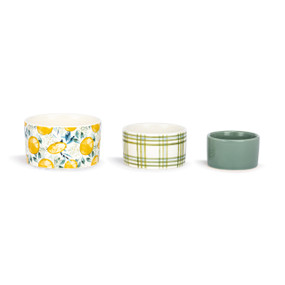 A set of three small ceramic nesting bowls in white, green and yellow lemon and plaid patterns.