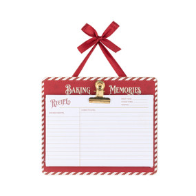 A small red and white clipboard hanging from a red ribbon. Attached to the clipboard is a pad of white blank recipe cards.