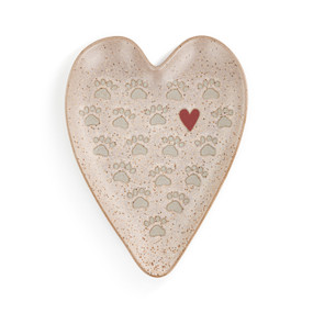 A tan heart shaped spoon rest with paw prints and a red heart.