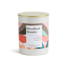 An 8 oz woodland wander scented candle in a round white container with a gold lid.
