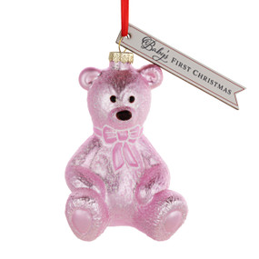 A pink teddy bear shaped ornament with a tag that says "Baby's First Christmas".
