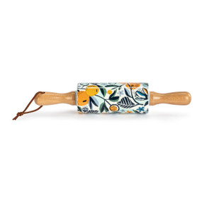 A small white decorative ceramic rolling pin with wood handles and a citrus illustration on the roller.