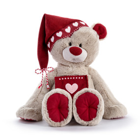 A light brown plush teddy bear with red accents on his ears and paws. He is wearing a red hat and has a red pocket on his chest.