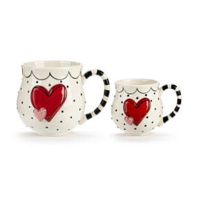 A set of two white mugs with black dots and raised red hearts on the front. One is smaller than the other.