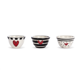 Three small white ceramic bowls with hearts on the front and different black and white dot and line patterns.