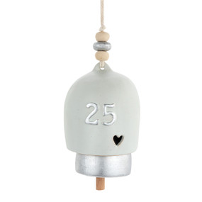 A cream and silver ceramic bell with the number 25 in silver on the front and a cut out heart.