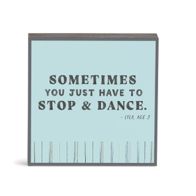 A blue wall art with the saying "Sometimes you just have to stop & dance".